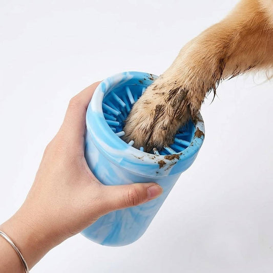 Portable dog paw cleaner cup with soft silicone bristles washing a muddy dog paw after a walk