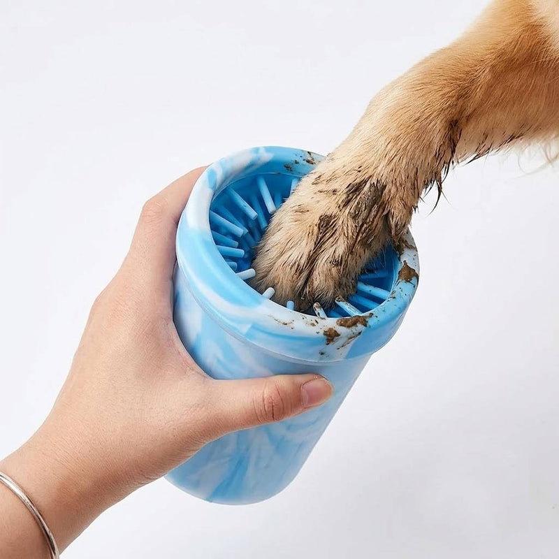 Portable dog paw cleaner cup with soft silicone bristles washing a muddy dog paw after a walk